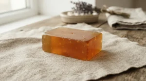Organic honey soap bar sitting on a folded natural linen towel in a spa setting
